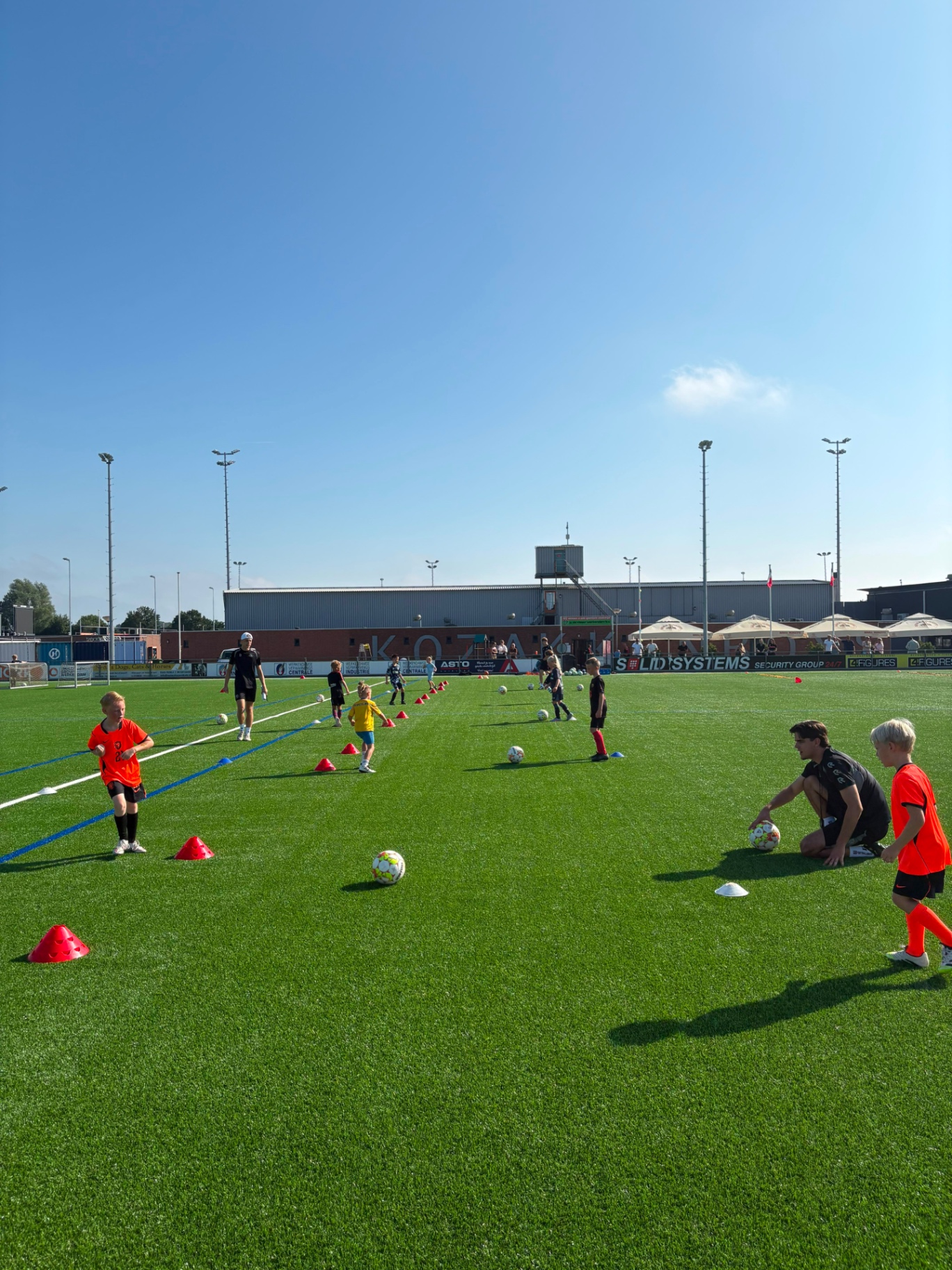 Brede veldshot van een groepstraining op Sportpark de Zwaaier