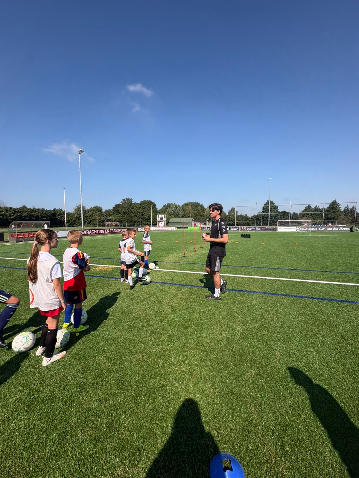 Coach coacht spelers 1-op-1 tijdens een groepstraining